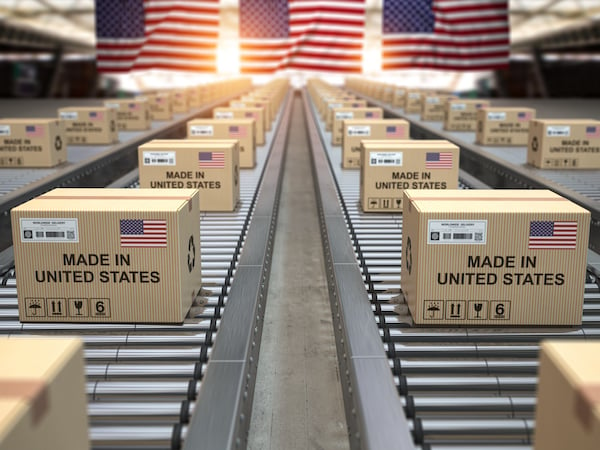 Cardboard boxes with text made in USA and american flag on the roller conveyor