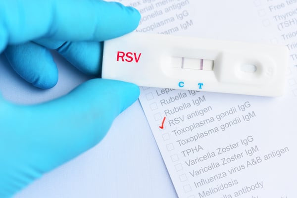 Photo of a positive RSV test beging held by a medial professional